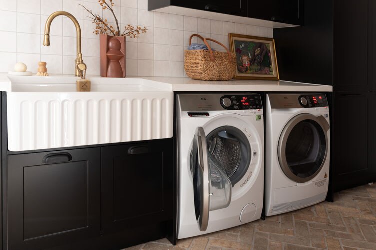 AEG modern black and gold laundry with washing machine and dryer